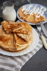 A stack of thin pancakes on a plate. Homemade pastries. Pancakes for breakfast. Appetizing food. Thin pancakes on a plate. Homemade crepes, tasty food. Staple of yeast pancakes.