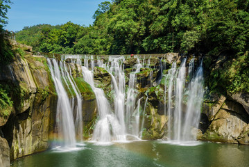 Morning view of the famous Shifen Waterfall with rainbow below