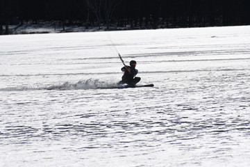 Man doing kiteboarding on frozen lake