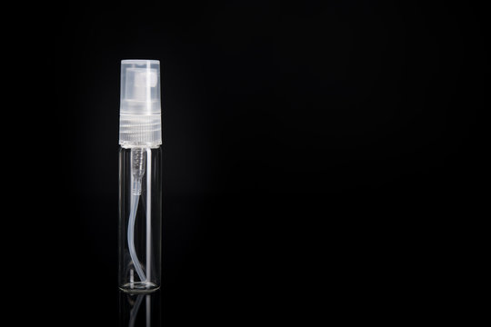 Glass bottle with spray atomizer. Bottle good for perfume sample or other liquids. Travel size 5ml On black background with copy space.