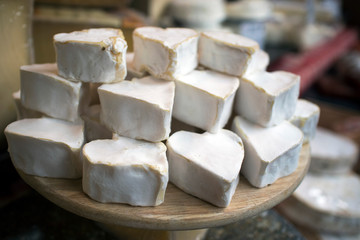 Soft heart-shaped Brie cheese at farmers market