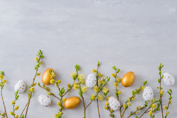 Flat lay easter composition with a willow branch and eggs on a gray background