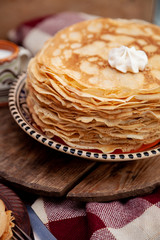 A stack of thin pancakes on a plate. Homemade pastries. Pancakes for breakfast. Appetizing food. Thin pancakes on a plate. Homemade crepes, tasty food. Staple of yeast pancakes.