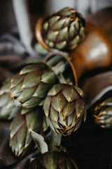 Obraz premium artichokes on grey background. fresh organic raw artichoke flowers in vase