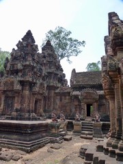 Naklejka premium Ruins of Angkor, temple of Banteay Srei, stone statue of guardians before pyramids, Angkor Wat, Cambodia