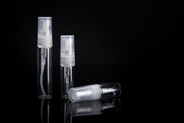 Glass bottle with spray atomizer. Bottles good for perfume samples or other liquids. Travel size 5ml, 3ml, 2ml. On black background with copy space.