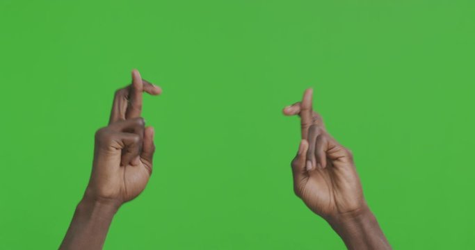 Male hands keeping fingers crossed, making wish
