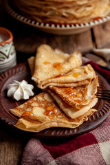 A stack of thin pancakes on a plate. Homemade pastries. Pancakes for breakfast. Appetizing food. Thin pancakes on a plate. Homemade crepes, tasty food. Staple of yeast pancakes.