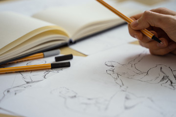 Figure drawing, sketching class. Male hands draw.