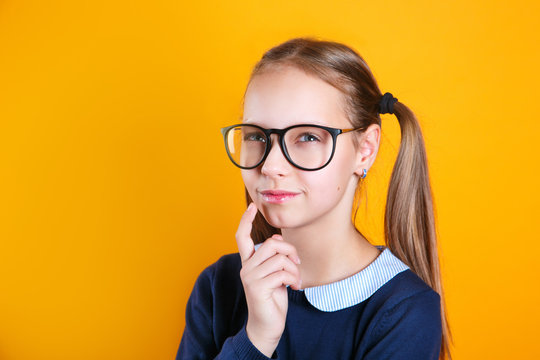 Pensive Charming School Girl 12 Years Old In Glasses On Yellow Background