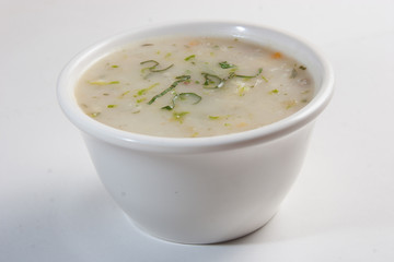 Closeup of a chicken soup served on a white bowl