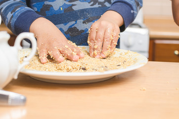 childrens hands making cookies on a wooden table