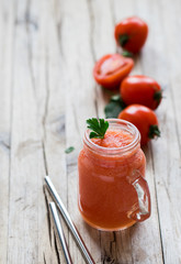 Vegan drink tomato smoothie with parsley in a jar on a wooden background in rustic style