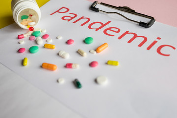 Multicolored pills, tablets against the virus, flu, disease. Medical concept of Virus Pandemic Protection.various pills. Text on background PANDEMIC.Virus protection concept,Focus on bottle.