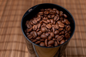 Coffee grinder with coffee beans  on a table.