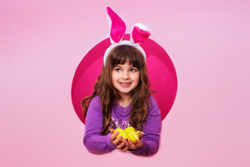 Obraz na płótnie Canvas Funny happy child girl with Easter eggs and bunny ears