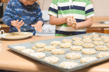 childrens hands making cookies on a wooden table