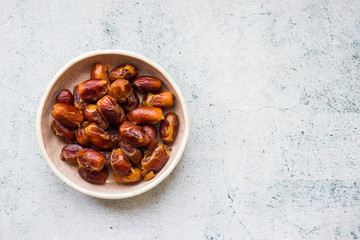 White dates in bowl on background
