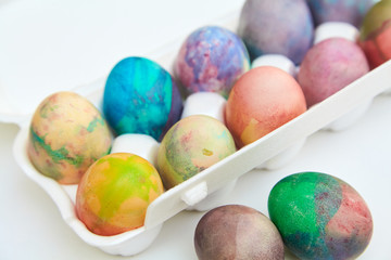 Group of Easter painted eggs in white container