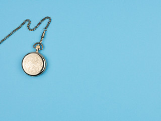 Fototapeta na wymiar Pocket watch on a chain on a blue background.