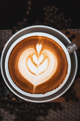 Closeup Coffee latte art leave from fresh milk foam on side of wood