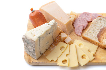 Close up view of different kinds of cheese and sausage isolated on wooden board.