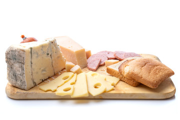 Food and eating concept - different kinds of cheese and sliced bread with sausages on wooden cutting board