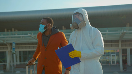 Near airport screening of passengers travellers african american man Covid-19 coronavirus symptoms temperature checkpoints mask infection epidemic corona passengers slow motion