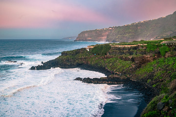 Colorful, misty sunset over the ocean, and the coastal cliffs of Northern Tenerife. Colorful Canary...