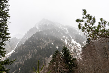 Mountain with fog and snow in National Park of Aigüestortes and lake of Sant Maurici.
