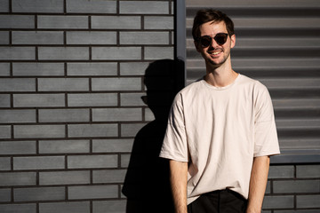 fashion guy posing in sunglasses against a black urban background