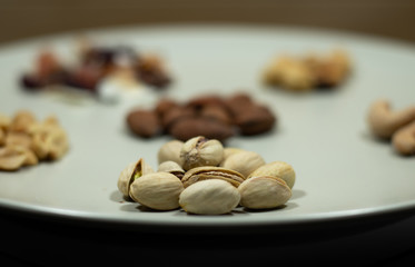 Different kinds of nuts in white dish Almonds, Pistachios, Cashews, peanut, hazelnut, Dry Fruits