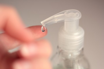 Closeup of a person applying anti-bacterial gel to disinfect their hands.