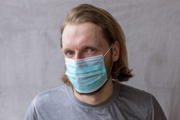 Man in blue medical protective mask to protect him from virus.  Pandemic. Health protection and...