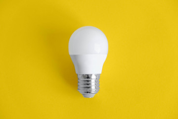 White light bulb on yellow background. Top view. Copy, empty space for text