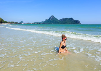 Young woman in bikini enjoying sandy beach on vacation