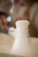 Experiments with dry ice for children. Smoke from the flask from reaction of dry ice with water,...