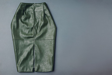 Trendy leather skirt. Spring female clothes outfit. Stylish green skirt from ecoligical material. Fashion. Space