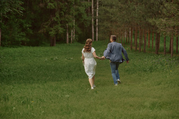 Naklejka na ściany i meble happy bride and groom run in the park