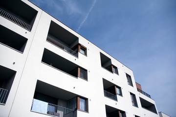 Exterior of new apartment buildings on a blue cloudy sky background. No people. Real estate business concept.