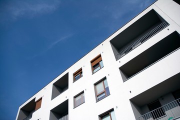 Exterior of new apartment buildings on a blue cloudy sky background. No people. Real estate business concept.