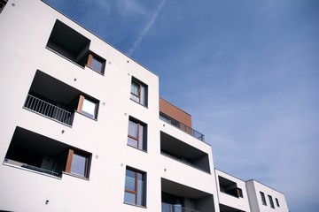Exterior of new apartment buildings on a blue cloudy sky background. No people. Real estate business concept.