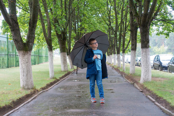 boy on the autumn street with an umbrella