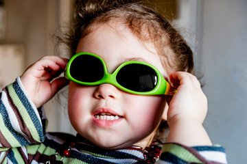 little girl in green sunglasses
