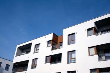 Exterior of new apartment buildings on a blue cloudy sky background. No people. Real estate business concept.