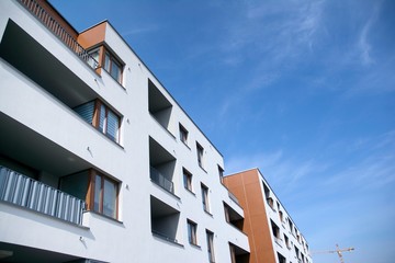 Exterior of new apartment buildings on a blue cloudy sky background. No people. Real estate business concept.