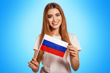 A beautiful young woman holds in her hands the flag of Russian Federation. Exchange student, learn...