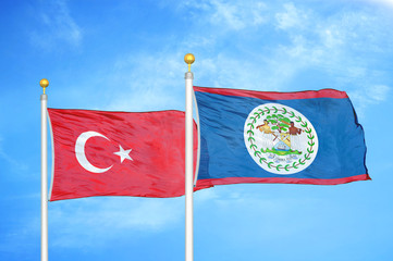Turkey and Belize two flags on flagpoles and blue cloudy sky
