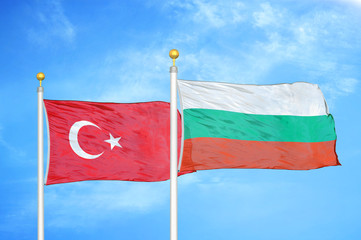 Fototapeta na wymiar Turkey and Bulgaria two flags on flagpoles and blue cloudy sky