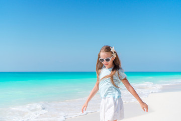 Fototapeta na wymiar Adorable little girl have fun at tropical beach during vacation